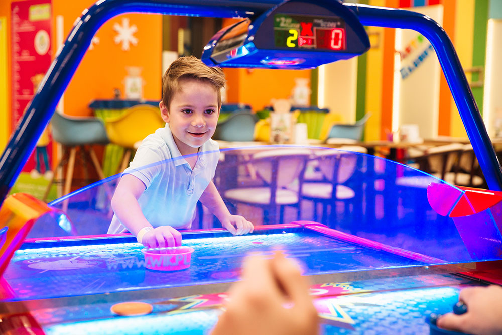 arcade-img-02 Young Boy Playing Air Hockey